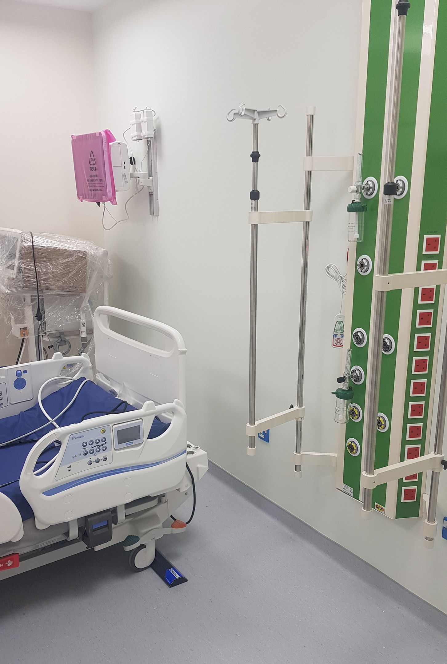 ICU room with a Hospital Bed ParkingTarget on the floor in front of the headwall services panel.