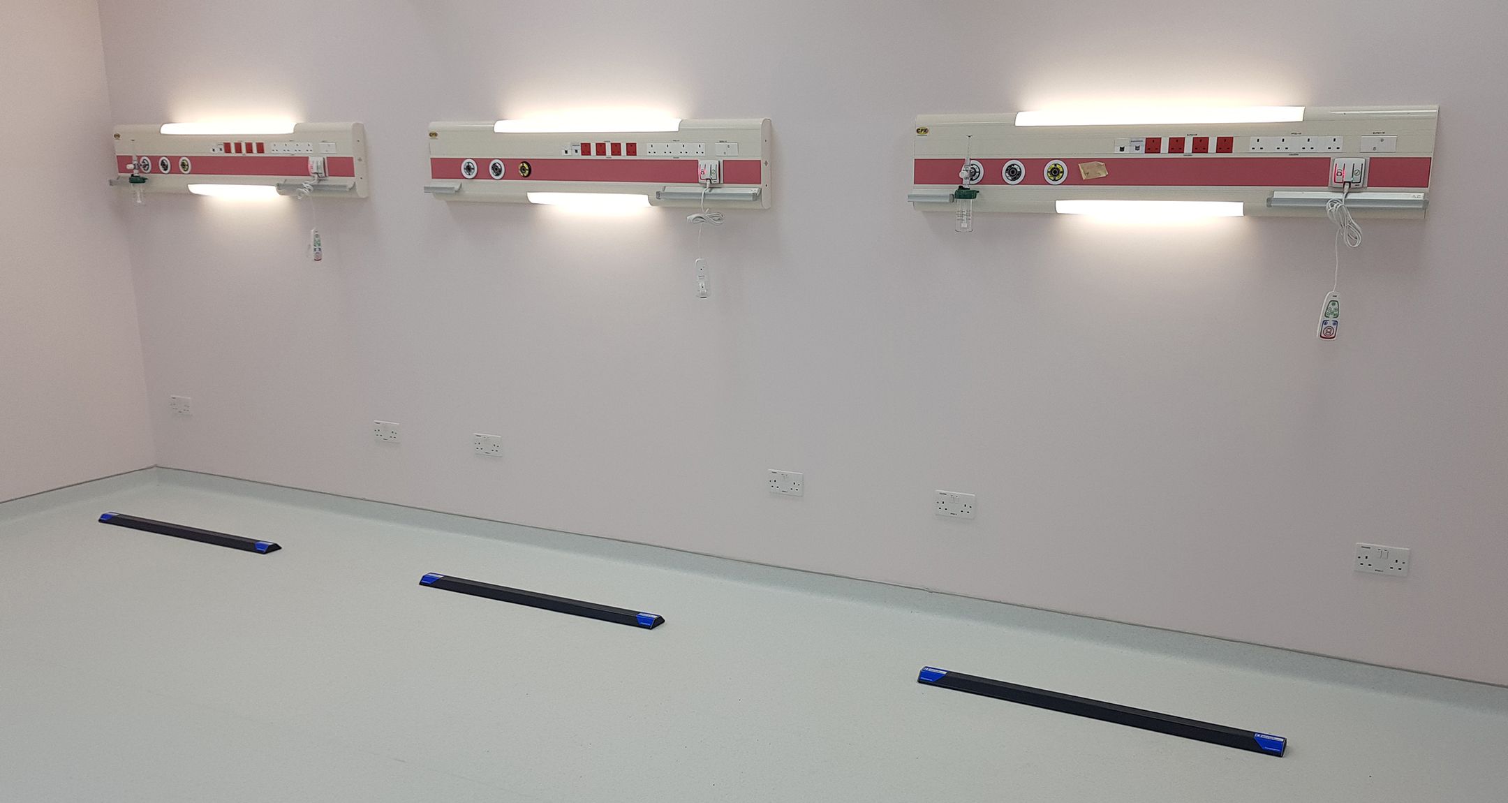 Maternity room with three bed bays, each with a Hospital Bed ParkingTarget installed on the floor in front of its headwall panel.